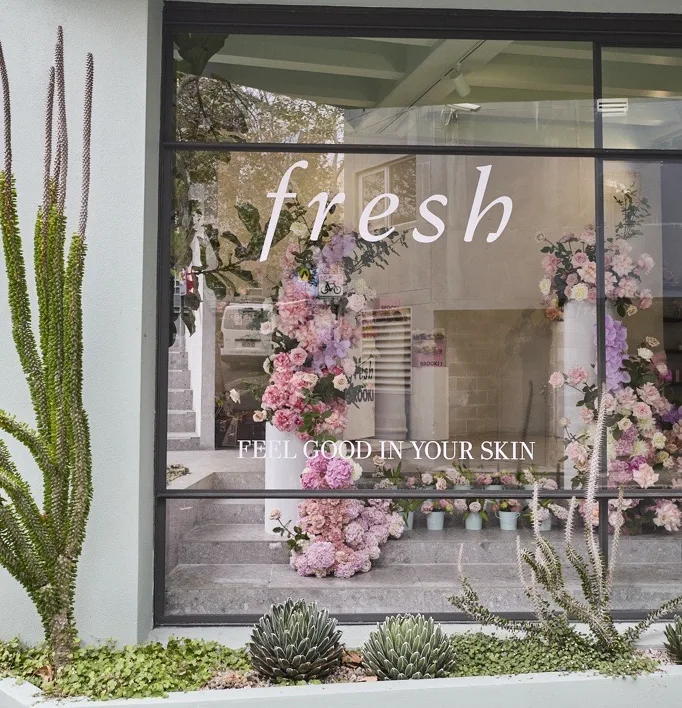 Fresh storefront window styled with a pastel floral installation